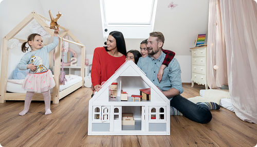 Familia jugando con la maqueta de madera de su futura casa